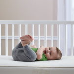 Baby lying on his back on the Sealy Crib Mattress