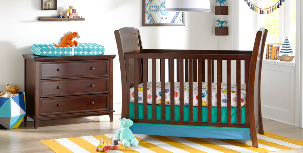 image of a nursery scene with oak colored crib and dresser. 
