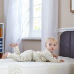 Toddler on his stomach on the Sealy Naturalis Hybrid 2-Stage Crib Mattress